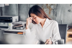 Young woman at work desk looking frustrated 