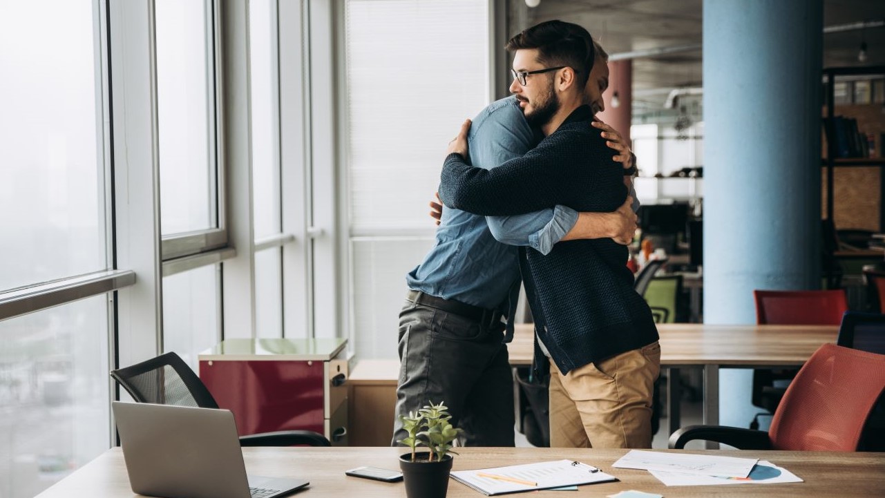 Employees hugging at work