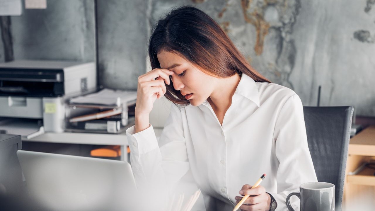 Young woman at work desk looking frustrated 